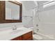 Well-lit bathroom boasts wood vanity and a shower-tub combination at 2923 Meadow Creek Ln, Monroe, NC 28110