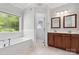 Bright bathroom with a soaking tub, double sinks and decorative mirrors at 2923 Meadow Creek Ln, Monroe, NC 28110