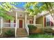 Inviting covered front porch with white railings and brick steps with nice landscaping at 2923 Meadow Creek Ln, Monroe, NC 28110