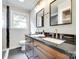 Bathroom featuring a dual sink vanity, stylish fixtures, and modern tiling at 3120 Parkway Ave, Charlotte, NC 28208