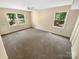 Neutral bedroom featuring carpet floors, two windows offering nice views and a ceiling fan for comfort at 3203 Oakdale Dr, Monroe, NC 28110