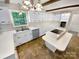 Bright kitchen features white cabinetry, a central island with cooktop, and a window offering outside views at 3203 Oakdale Dr, Monroe, NC 28110