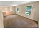 Spacious living room with carpet flooring, large windows offering outside views and neutral colored walls at 3203 Oakdale Dr, Monroe, NC 28110