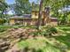 Rear view of a brick home with chimney and trees, set on a green lawn at 3203 Oakdale Dr, Monroe, NC 28110