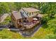 Aerial view of a brick and siding home with a spacious deck, mature trees, and a well-manicured lawn at 341 N Mulberry St, Statesville, NC 28677