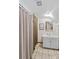 Small bathroom with white vanity, tiled floor, framed mirror and shower with neutral-toned curtain at 341 N Mulberry St, Statesville, NC 28677