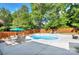 Well-maintained backyard pool with a patio, surrounded by green trees and a privacy fence at 3632 Cole Mill Rd, Charlotte, NC 28270