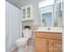 Well-lit bathroom with vanity, toilet, shower curtain, and a mirrored medicine cabinet at 3632 Cole Mill Rd, Charlotte, NC 28270