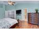 Spacious main bedroom with hardwood floors, ceiling fan, tv, and a glimpse of the landing at 3632 Cole Mill Rd, Charlotte, NC 28270