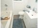 Bright bathroom features a white vanity, marble tile, and soaking tub at 383 Camden Nw Ct, Concord, NC 28027