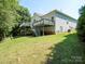 Exterior view of a two-story home with a large deck, landscaped yard and mature trees, ideal for outdoor living at 4028 Garden Oak Dr, Indian Trail, NC 28079