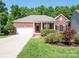 Charming brick home with a well-manicured lawn and beautiful landscaping at 4028 Garden Oak Dr, Indian Trail, NC 28079
