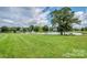 Scenic community pond with a fountain, mature trees, and a bench, offering a peaceful outdoor space at 4028 Garden Oak Dr, Indian Trail, NC 28079