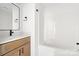 Bright bathroom features a wood vanity, quartz countertop and a white tub and shower at 413 Jose St, Shelby, NC 28150