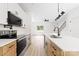 Bright kitchen featuring an island, stainless steel appliances, white cabinets, and light wood flooring at 413 Jose St, Shelby, NC 28150
