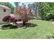 Green backyard featuring mature trees and colorful landscaping, perfect for a serene outdoor setting at 417 Florence Cir, Statesville, NC 28625