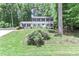 Charming two-story home featuring a well-manicured lawn, mature trees, and a welcoming blue front door at 417 Florence Cir, Statesville, NC 28625