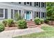 Inviting front entryway with a bright blue door, brick steps, and decorative shrubs and black shutters at 417 Florence Cir, Statesville, NC 28625