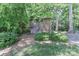 Backyard featuring a well-maintained storage shed surrounded by mature trees and manicured greenery at 417 Florence Cir, Statesville, NC 28625