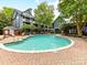 Community pool surrounded by lounge chairs and lush greenery, offering a relaxing outdoor space at 517 N Graham St # 3E, Charlotte, NC 28202