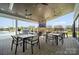 An outdoor patio area with ample seating, ceiling fans, a brick fireplace with a TV, and views of the community pool at 527 Sunharvest Ln, Indian Trail, NC 28079