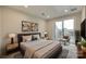 Bedroom with neutral color scheme, recessed lighting, bedside tables, and a sliding glass door to an outdoor deck at 556 Billingsley Rd, Charlotte, NC 28211