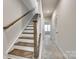 Hallway with staircase and carpet runner, showcasing the home's design and layout at 556 Billingsley Rd, Charlotte, NC 28211