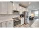 Modern kitchen featuring white cabinets, stainless steel appliances and wood-look flooring at 556 Billingsley Rd, Charlotte, NC 28211