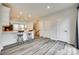 Open living space with white kitchen island, bar seating, and modern gray wood flooring at 556 Billingsley Rd, Charlotte, NC 28211