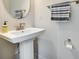 Close-up of powder room featuring pedestal sink, round mirror, and neutral wall color at 556 Billingsley Rd, Charlotte, NC 28211