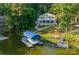 Aerial view of a lakefront home, expansive yard, and covered boat dock at 592 Shoreline Rd, New London, NC 28127