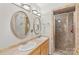 Bathroom showcasing double sinks, decorative mirrors, tile floor and shower with glass door at 592 Shoreline Rd, New London, NC 28127
