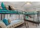 Bedroom featuring three bunk beds with blue accents, carpet flooring, and a ceiling fan at 592 Shoreline Rd, New London, NC 28127
