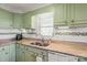 Kitchen featuring light green cabinets, granite counters, and updated appliances with ample natural light at 592 Shoreline Rd, New London, NC 28127