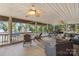 Beautiful screened-in porch with lake views, ceiling fans, and comfortable seating area at 592 Shoreline Rd, New London, NC 28127
