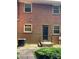 Brick townhouse back view features windows, door to a small deck with black railing and stone walkway at 623 S New Hope Rd # 9, Gastonia, NC 28054