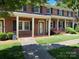 Charming brick townhouse featuring a covered front porch, black shutters, and manicured lawn at 623 S New Hope Rd # 9, Gastonia, NC 28054