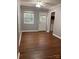 Room features an exterior door, light gray walls, white trim, ceiling fan and wood grain laminate flooring at 623 S New Hope Rd # 9, Gastonia, NC 28054