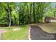 Tranquil backyard with mature trees, shed, and landscaped features at 6713 William Harry Ct, Charlotte, NC 28211