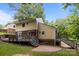 Exterior view of a charming two-story home featuring a wooden deck, brick patio, and lush green lawn at 6713 William Harry Ct, Charlotte, NC 28211