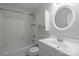Clean bathroom with tiled walls, round mirror, and bath/shower combo at 6713 William Harry Ct, Charlotte, NC 28211