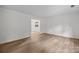 Hardwood floors accent this spare bedroom's neutral paint and open doorway at 6713 William Harry Ct, Charlotte, NC 28211