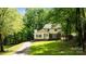 Inviting exterior of a two-story home framed by mature trees and a sprawling front lawn at 6713 William Harry Ct, Charlotte, NC 28211