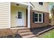 Inviting front entrance with a white door, brick steps, and manicured landscaping at 6713 William Harry Ct, Charlotte, NC 28211