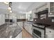 Modern kitchen with stainless steel appliances, granite countertops, and dark backsplash at 6713 William Harry Ct, Charlotte, NC 28211