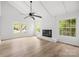 Bright living room features a painted brick fireplace and wood flooring at 6713 William Harry Ct, Charlotte, NC 28211