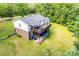 Back of home with a large wooden deck and stairs leading to yard at 679 Fairforest Rd, Chester, SC 29706