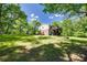 Expansive backyard featuring a deck, storage shed, and mature trees, perfect for outdoor living at 679 Fairforest Rd, Chester, SC 29706