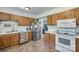Functional kitchen featuring stainless steel appliances, wood cabinets, and durable tile flooring at 679 Fairforest Rd, Chester, SC 29706