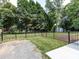 Fenced backyard with lawn and small storage shed at 6922 Woodstock Dr, Charlotte, NC 28210